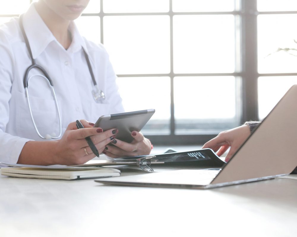 Payment Posting Medicine. Beautiful doctor by the table
